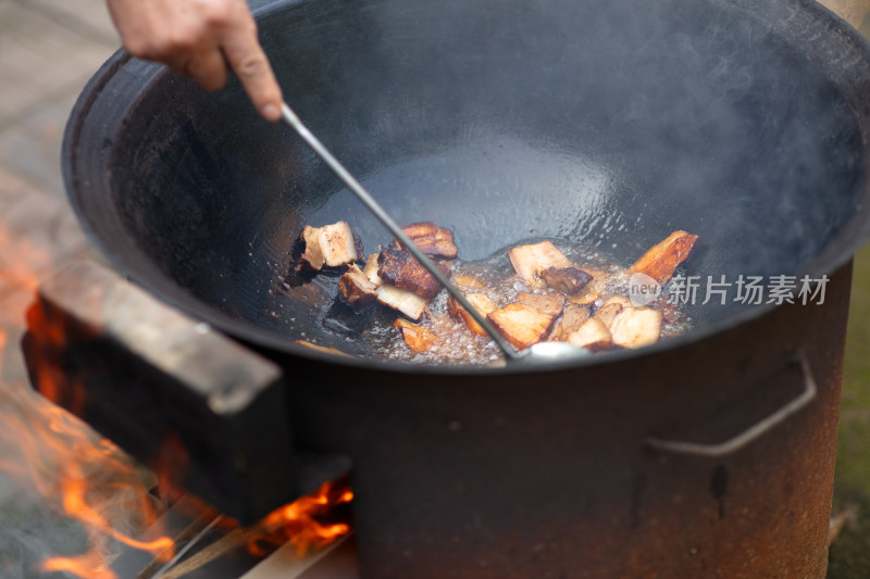 柴火铁锅里煸炒五花肉