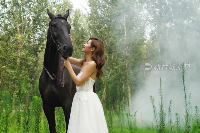 草地上漂亮的青年女人和马