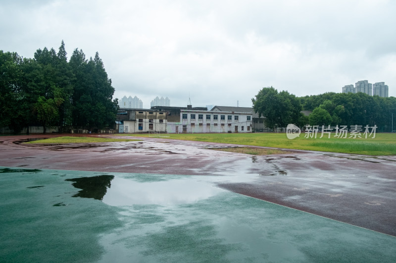 雨后的空旷操场及周边老旧建筑景象