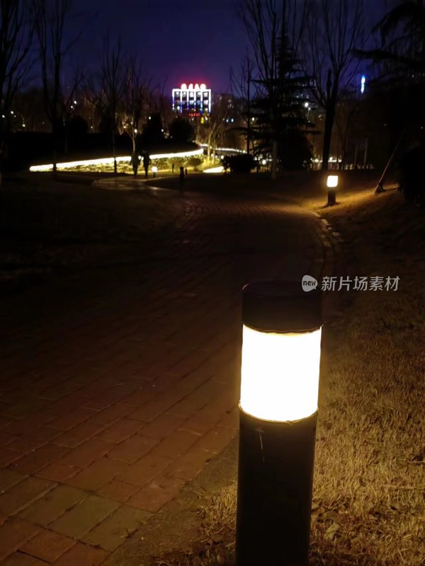 夜晚亮灯的公园小径及远处夜景