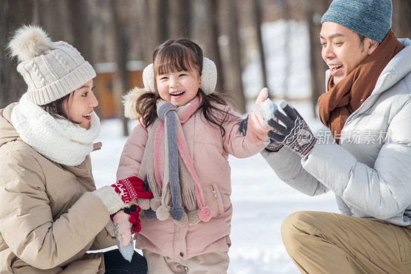 一家三口在雪地里玩耍