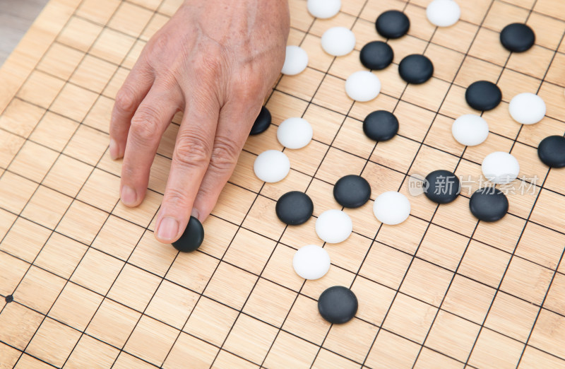 俯视拍摄手拿围棋棋子在棋盘上落子