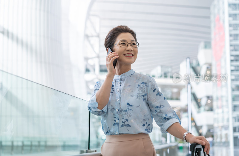 老年女人在机场打电话