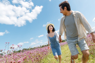 青年夫妇手牵手在花海里奔跑