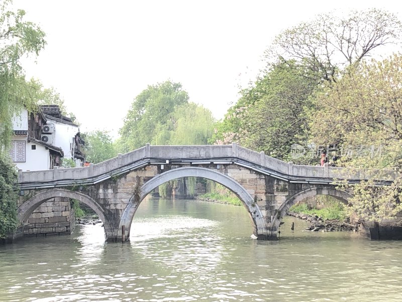 水上石桥与周边绿植相映成趣的风景