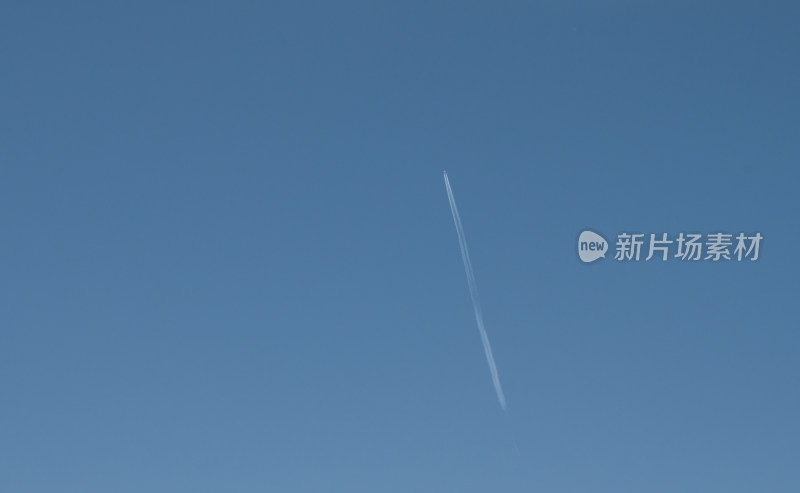 在蓝色天空背景下飞行的飞机拖尾