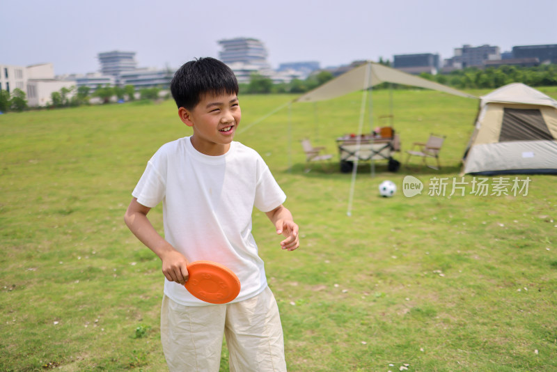 可爱的小男孩在草地上玩飞盘