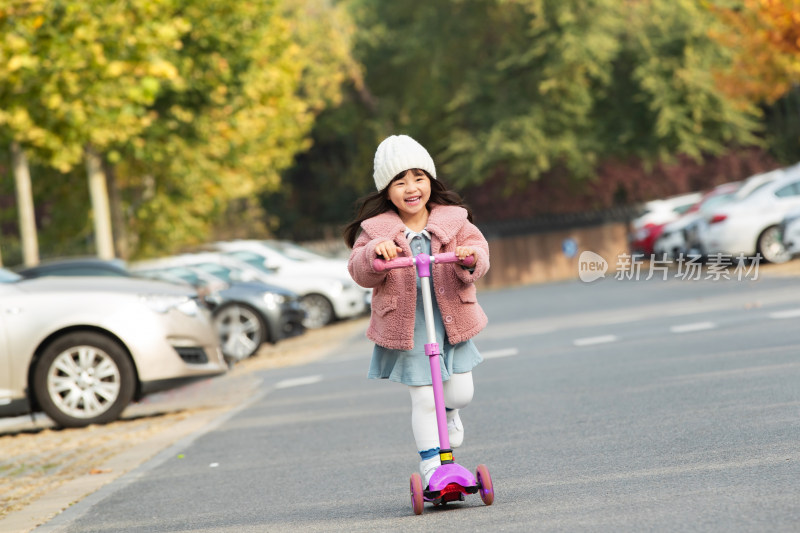 快乐的小女孩在户外玩滑板车