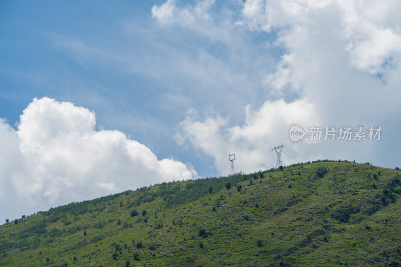 蓝天白云下的绿意盎然的山丘风景