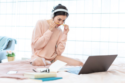 年轻女子在床上使用电脑