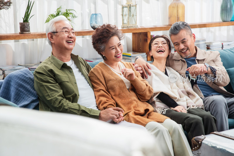 两对快乐的老年夫妇坐在沙发上聊天