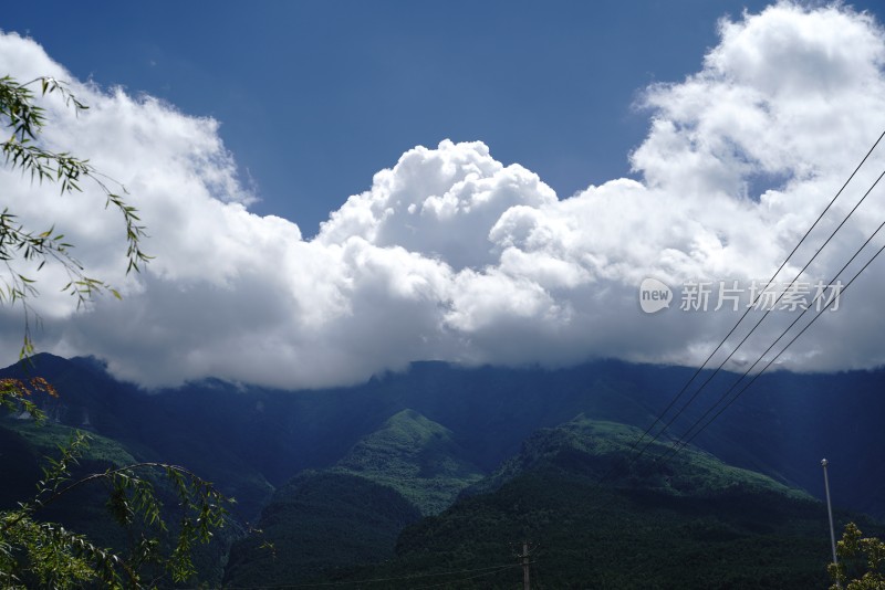 蓝天下白云缭绕的葱郁山脉景观