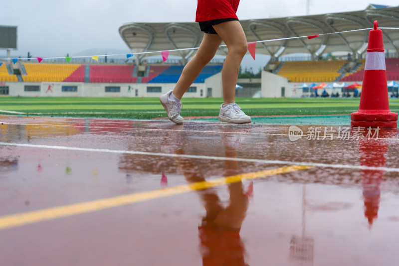 雨中跑道上奔跑的田径运动员