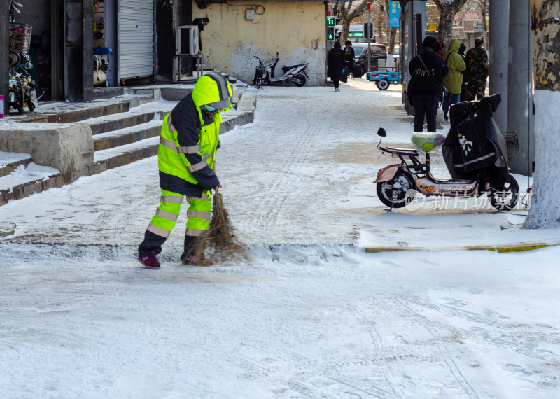 在马路上扫雪的环卫工人