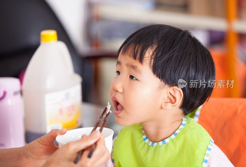 正在给亚洲面孔的小女孩喂饭