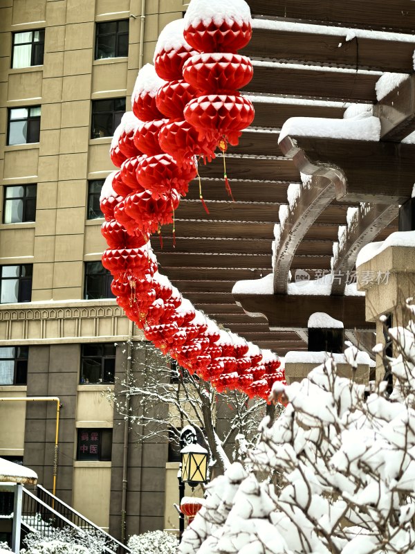 挂雪建筑旁挂着红灯笼的雪景