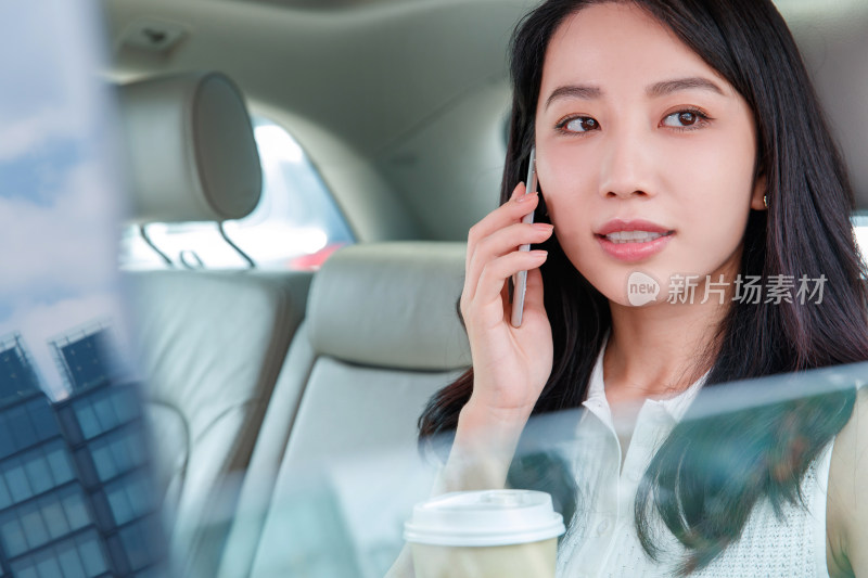 商务女性坐在汽车里打电话