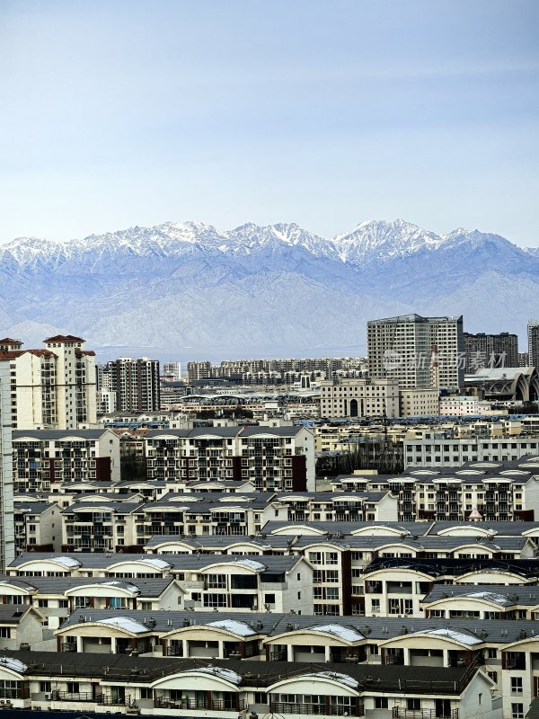 城市建筑群与雪山远景