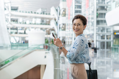 老年女人在机场使用手机