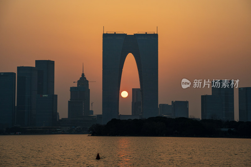 夕阳下的苏州工业园区，太阳穿过东方之门