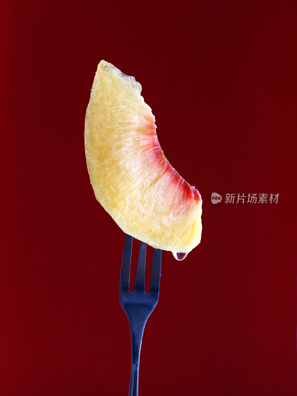 红色背景上，新鲜水果黄桃果肉的特写
