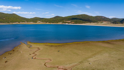 文海村航拍广阔水域边的草地及周边群山