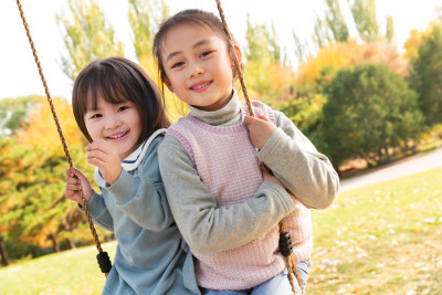 两个女孩在公园里荡秋千