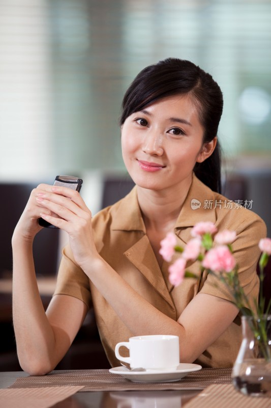 年轻商务女士在咖啡厅使用手机