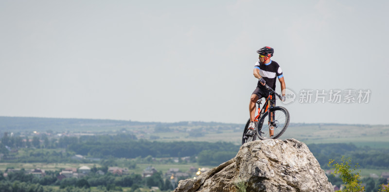 男子山顶骑山地车眺望远方