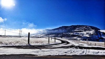 雪后山间弯曲道路与蓝天相映的景象