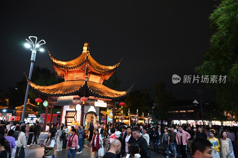夜晚古亭前人潮涌动景象