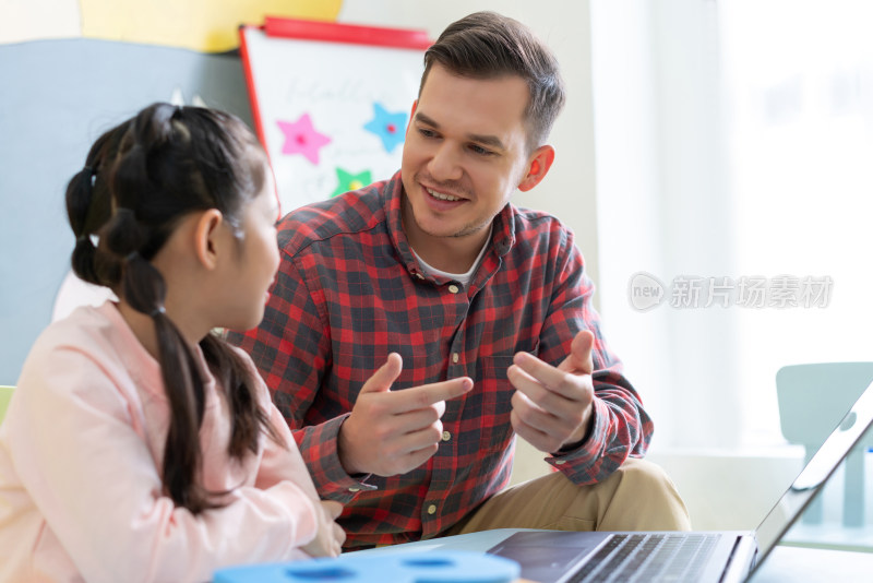 老师在课堂上辅导小学生用电脑