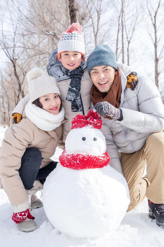 一家三口在雪地里堆雪人