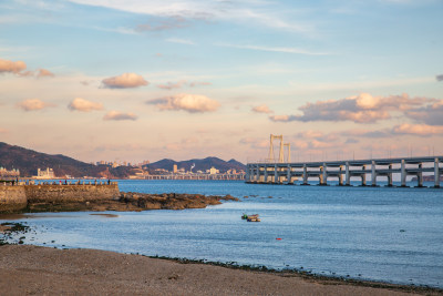 黄昏日落时的大连黑石礁公园海滩和跨海大桥