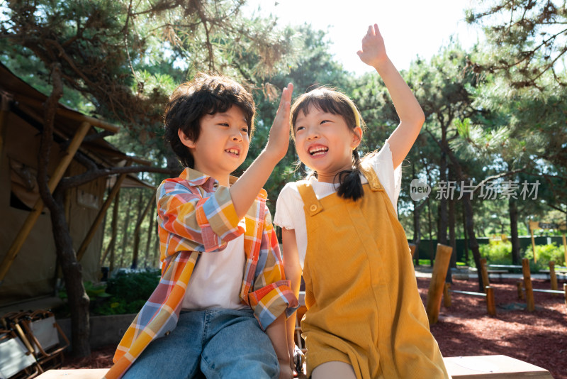 两个小孩子开心击掌庆祝