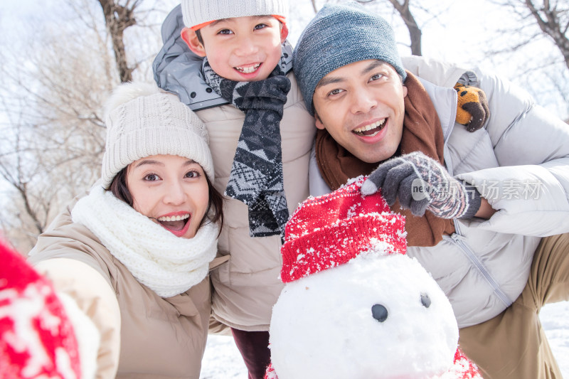 一家三口在雪地里堆雪人