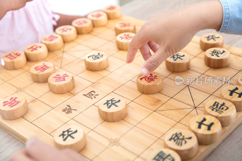 小女孩在和妈妈下中国象棋