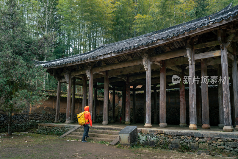 身着亮色外套的人参观时思寺古旧木质建筑