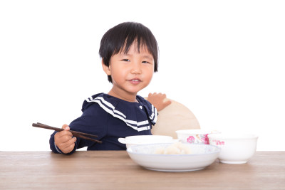 餐桌前即将吃饱而玩耍的中国小女孩