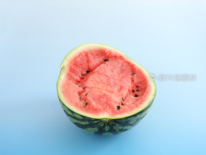 蓝色背景上，用勺子挖西瓜吃的夏日乐趣