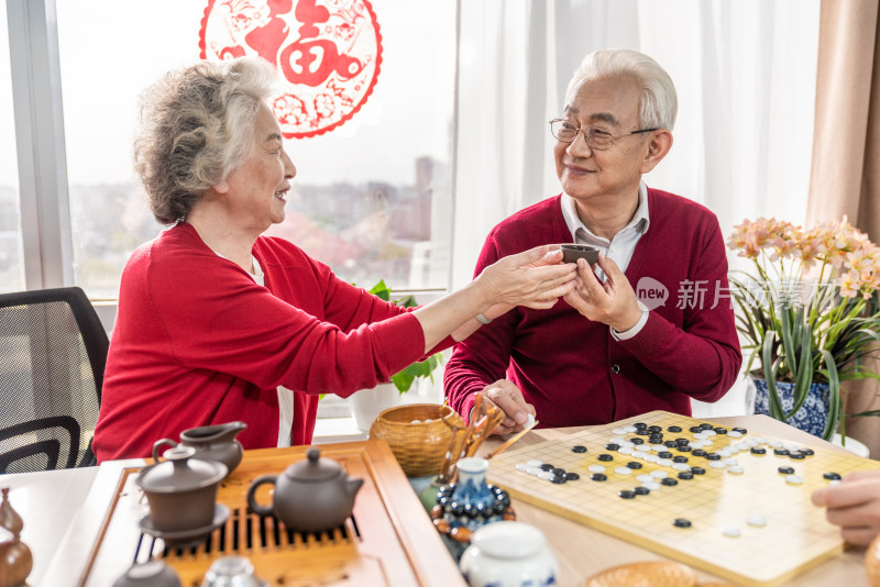 快乐的老年夫妇喝茶下围棋
