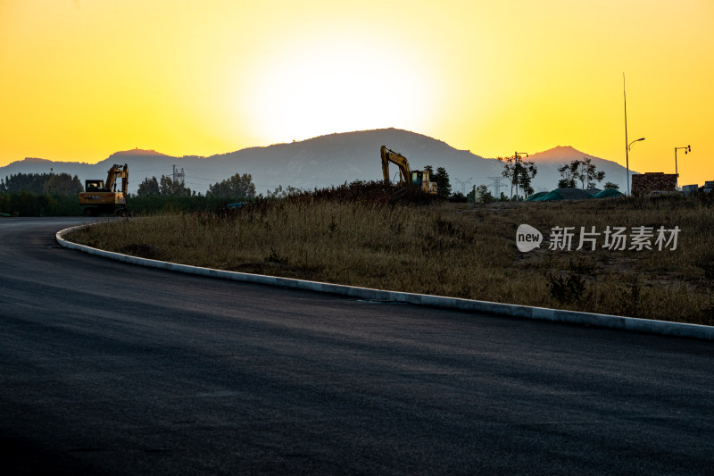 夕阳下道路上的挖掘机