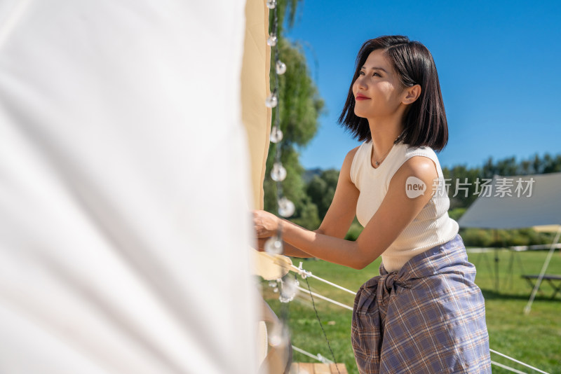 女孩在露营地搭建帐篷