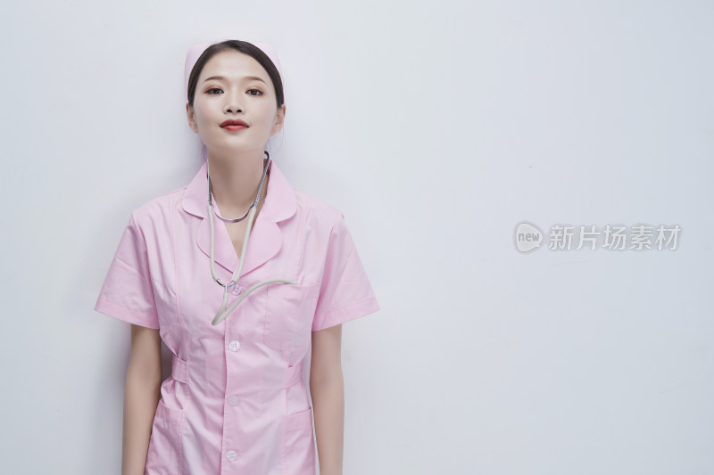 身穿粉色护士服佩戴听诊器的女性医护人员