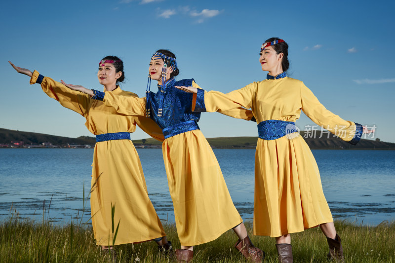 草原上穿着蒙古族传统服饰的年轻蒙族姐妹