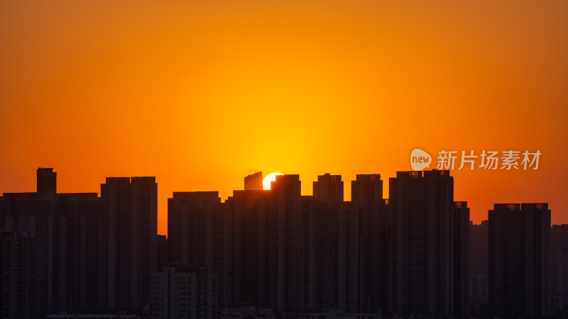 清晨城市高层住宅与日出太阳