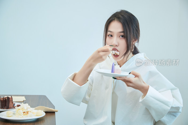 在烘焙店吃蛋糕喝饮料的可爱亚洲少女