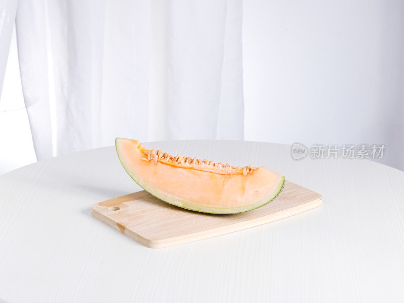 白色桌面上摆放着切开的新鲜水果哈密瓜
