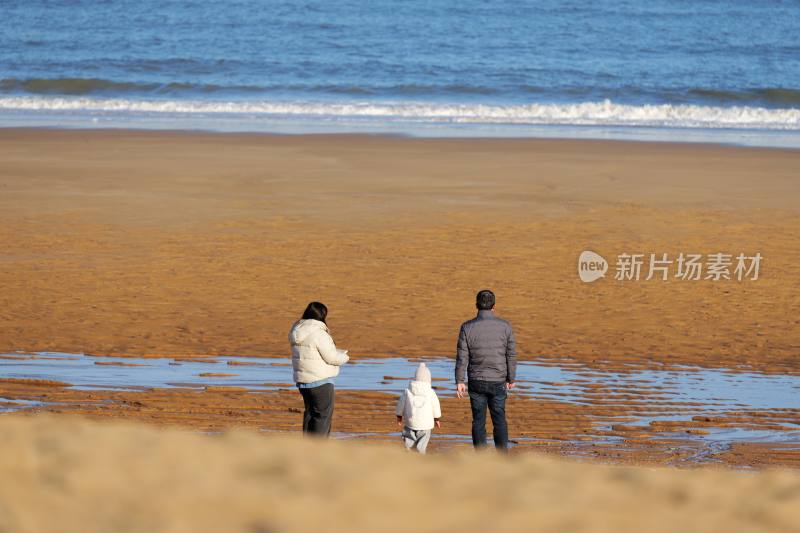 冬日漫步海边的一家人