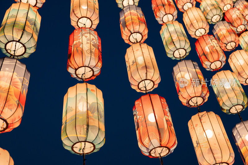 画着中国风图案的灯笼在蓝色的夜空下发着光